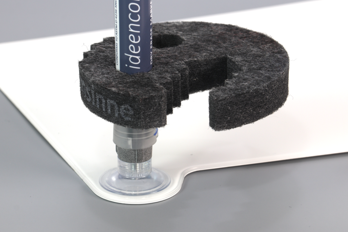 Nahaufnahme eines Whiteboard-Ideenbretts mit flacher Ecke von imsinne GmbH. Es zeigt einen blauen Marker, der von einem Saugnapf aufrecht gehalten wird. Ein schwarzes Schaumstoffmaterial stabilisiert den Marker und lässt teilweise „Ideen“ frei, was an die Verwendung von Ideenbrettern erinnert.